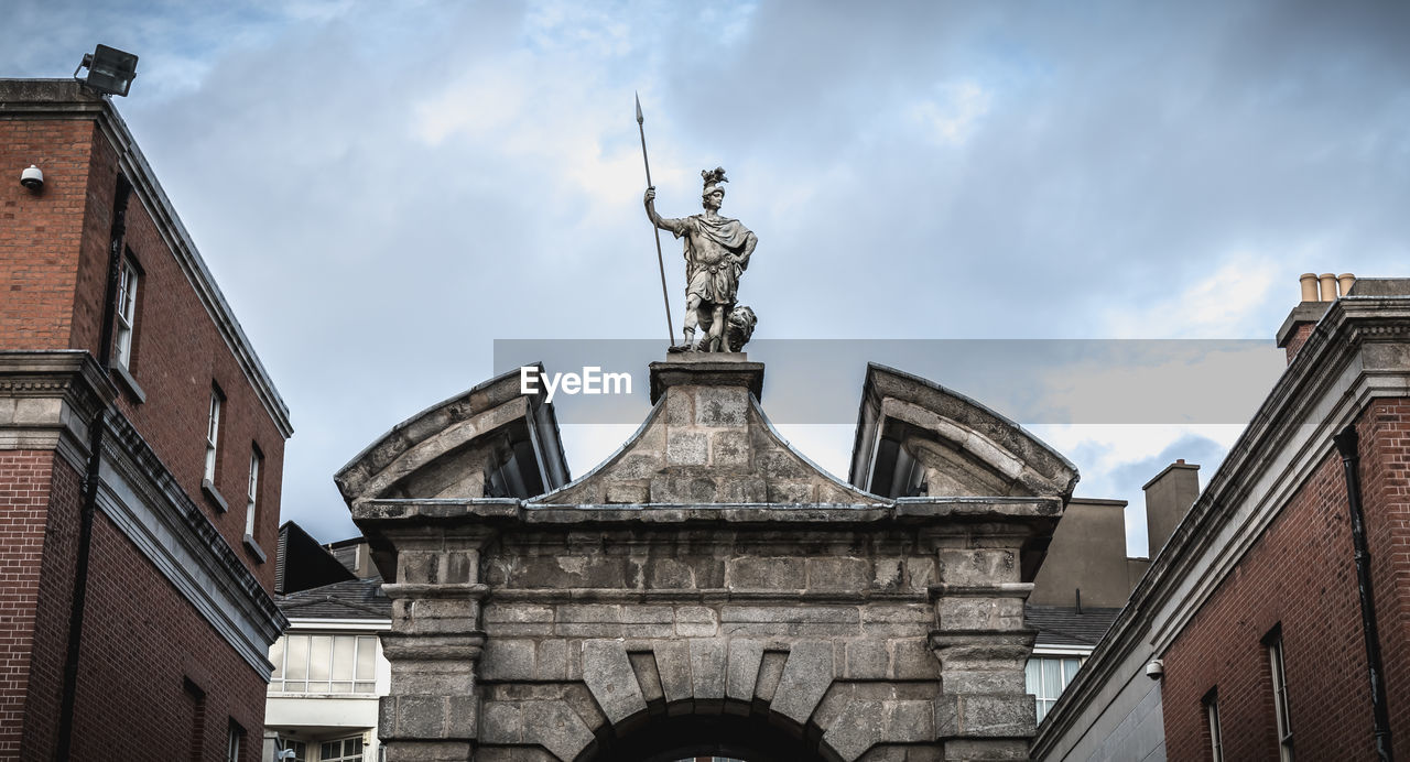 LOW ANGLE VIEW OF STATUE AGAINST BUILDING