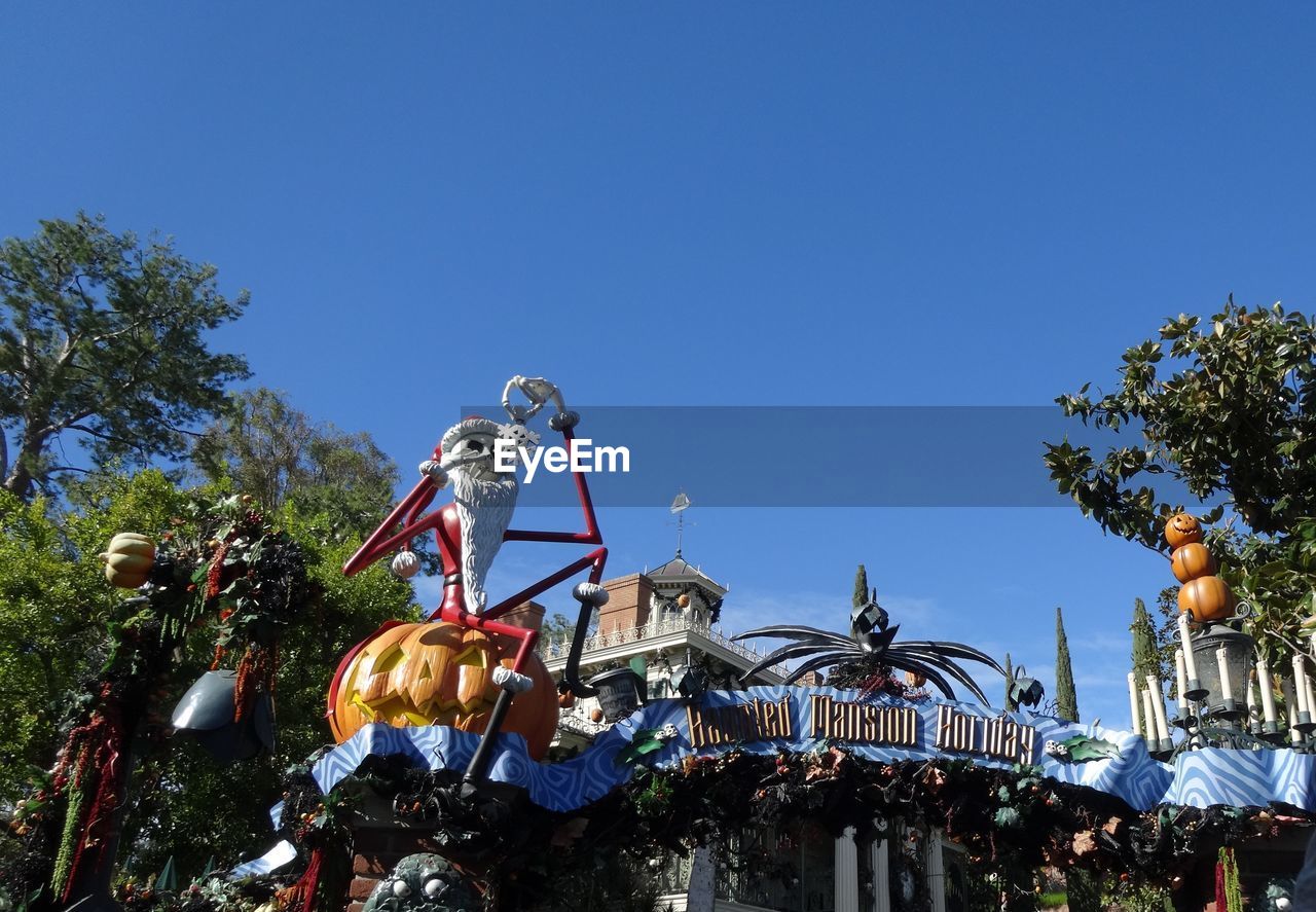 LOW ANGLE VIEW OF AMUSEMENT PARK AGAINST BLUE SKY