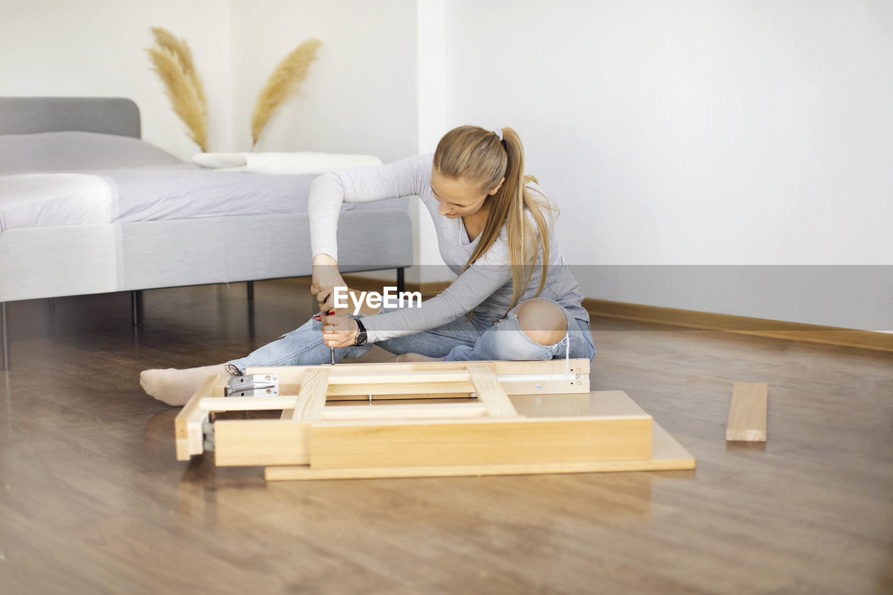 Woman fixing furniture at home