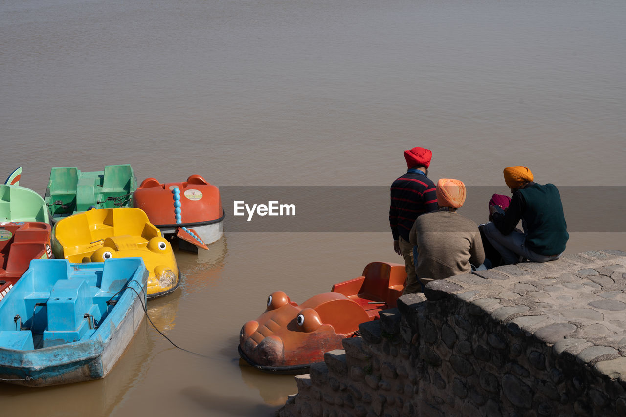 HIGH ANGLE VIEW OF PEOPLE IN TOYS AT LAKE