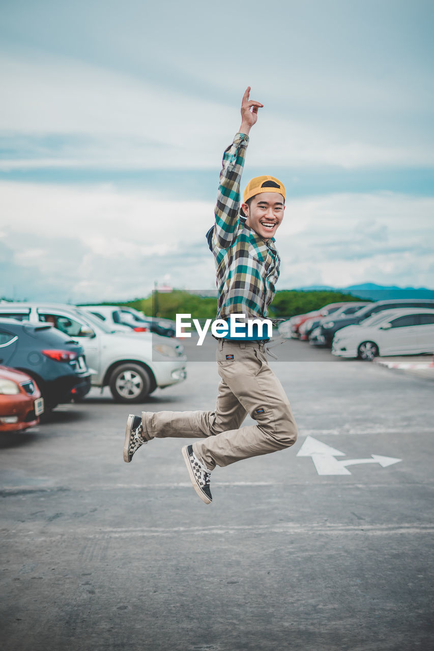 Full length of young man jumping on street in city