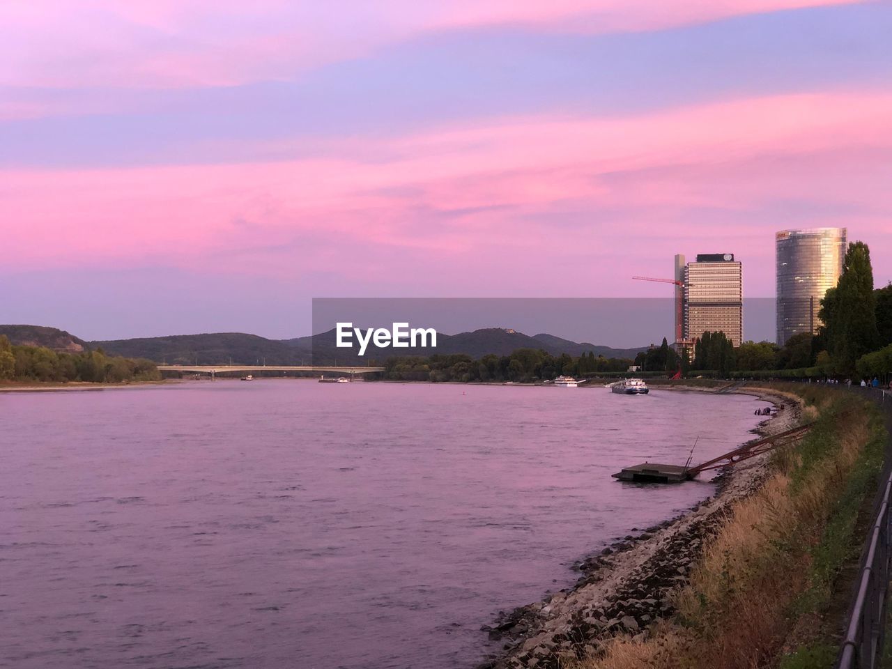 Scenic view of sea by buildings against sky during sunset