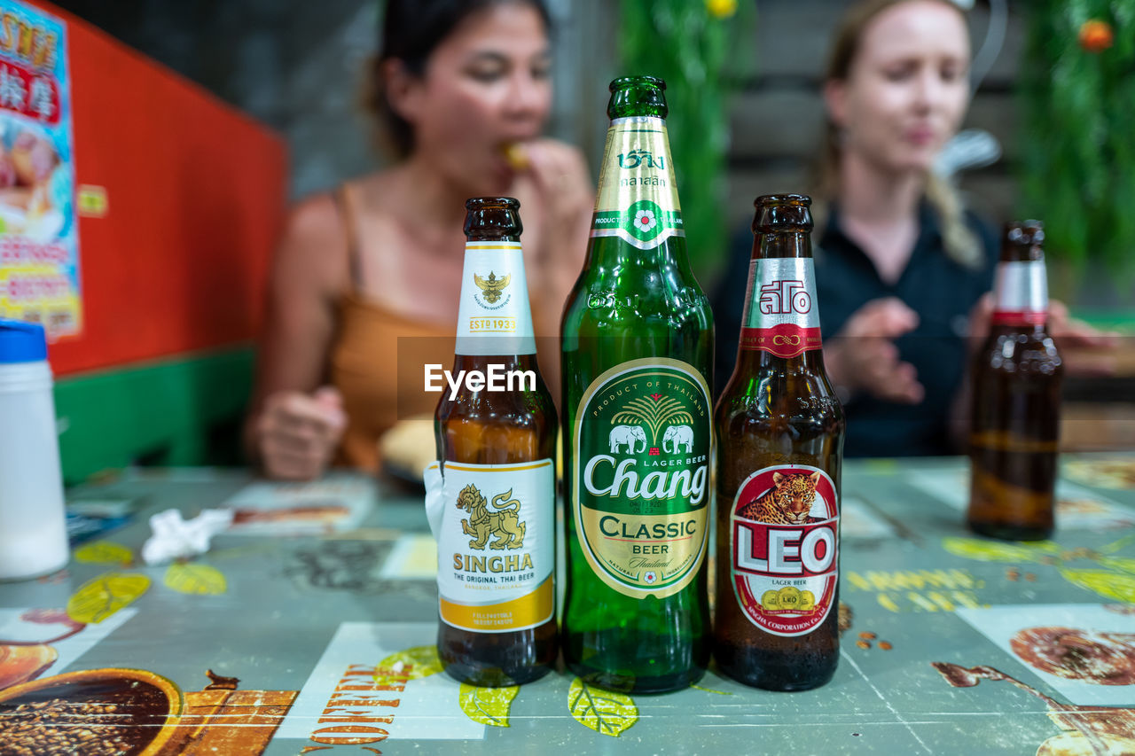 CLOSE-UP OF BEER BOTTLES ON TABLE AT BAR