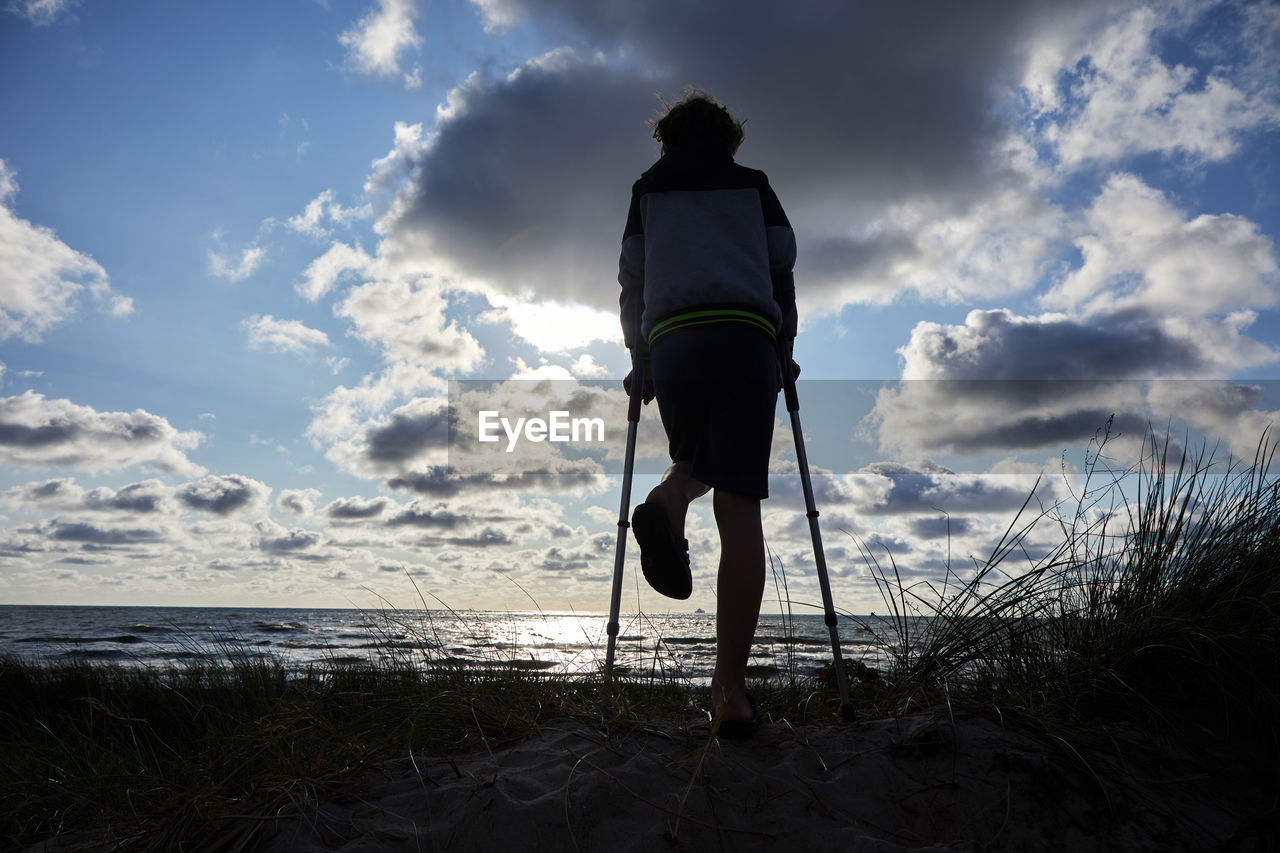 REAR VIEW OF MAN AT BEACH