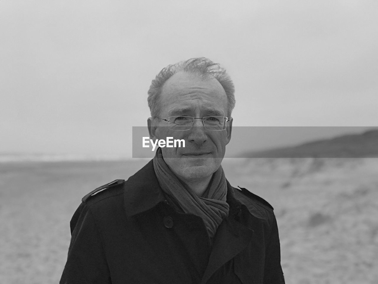 Portrait of man standing at beach against sky