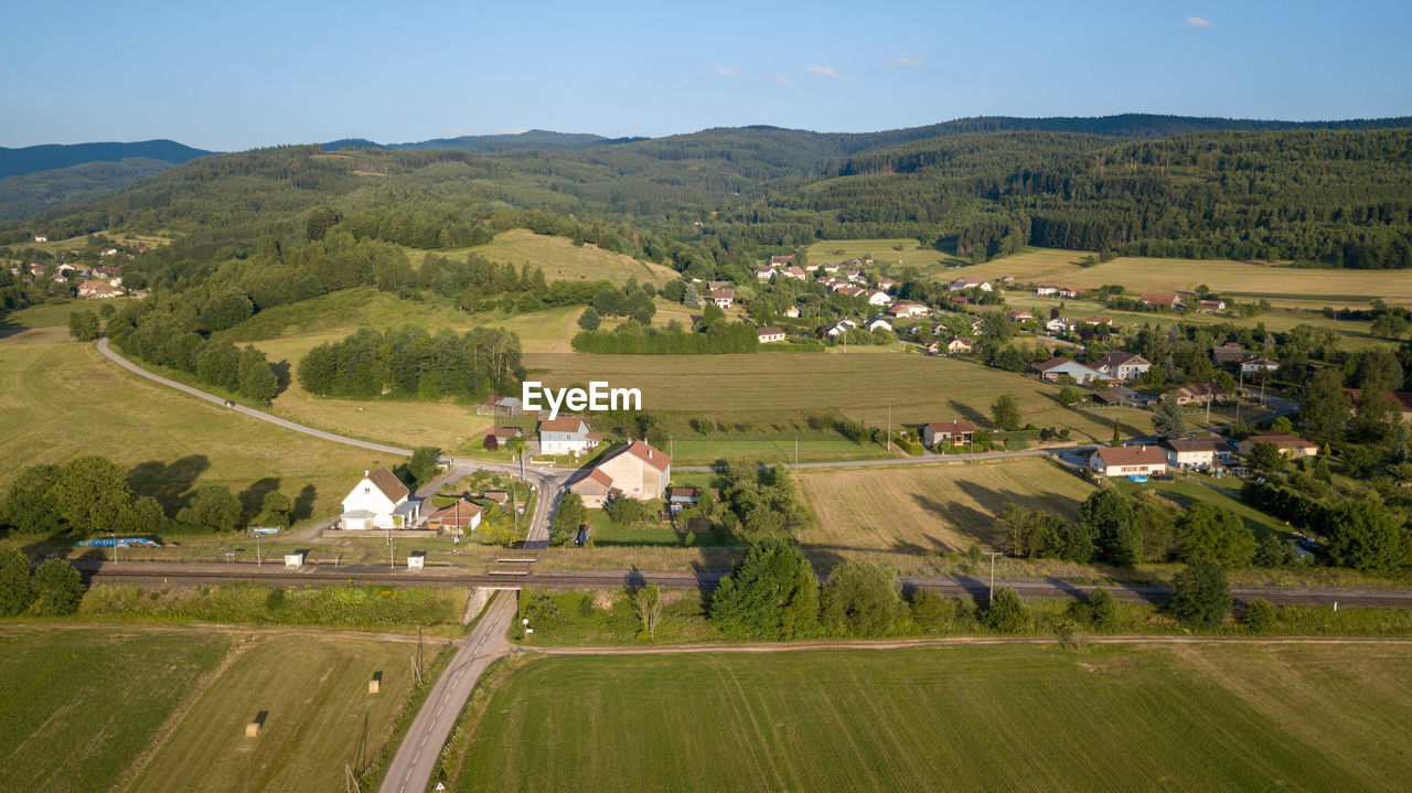 High angle view of houses and agricultural field against sky