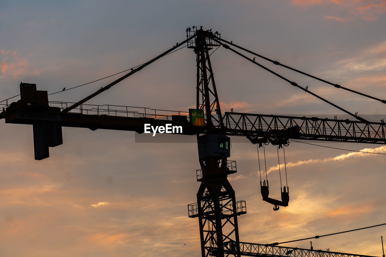LOW ANGLE VIEW OF SILHOUETTE CRANES AGAINST SKY