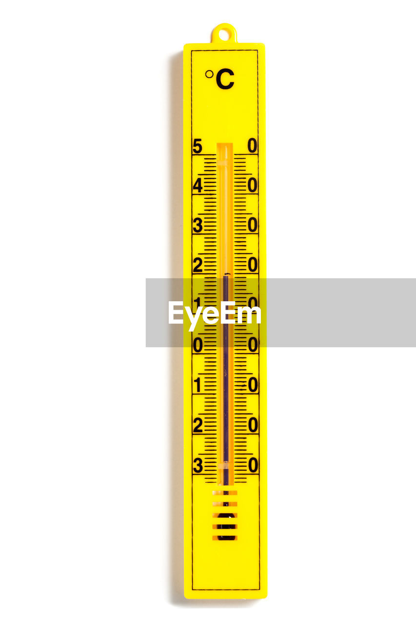 Close-up of yellow thermometer over white background