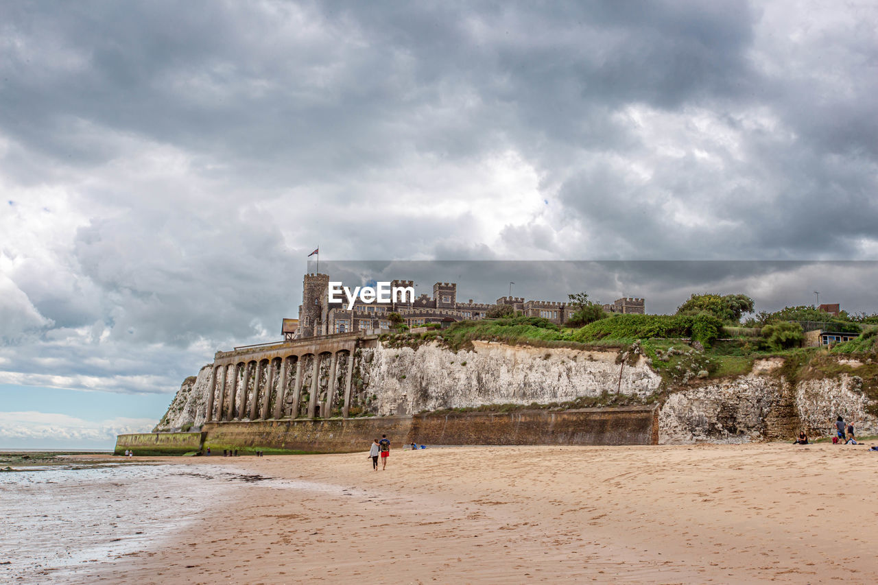 Scenic view of beach against cloudy sky