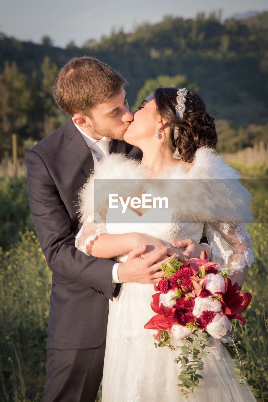 YOUNG COUPLE KISSING ON FLOWER