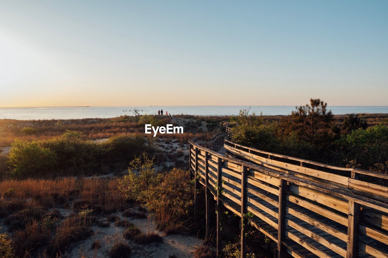 Scenic view of sea and boardwalk against clear sky