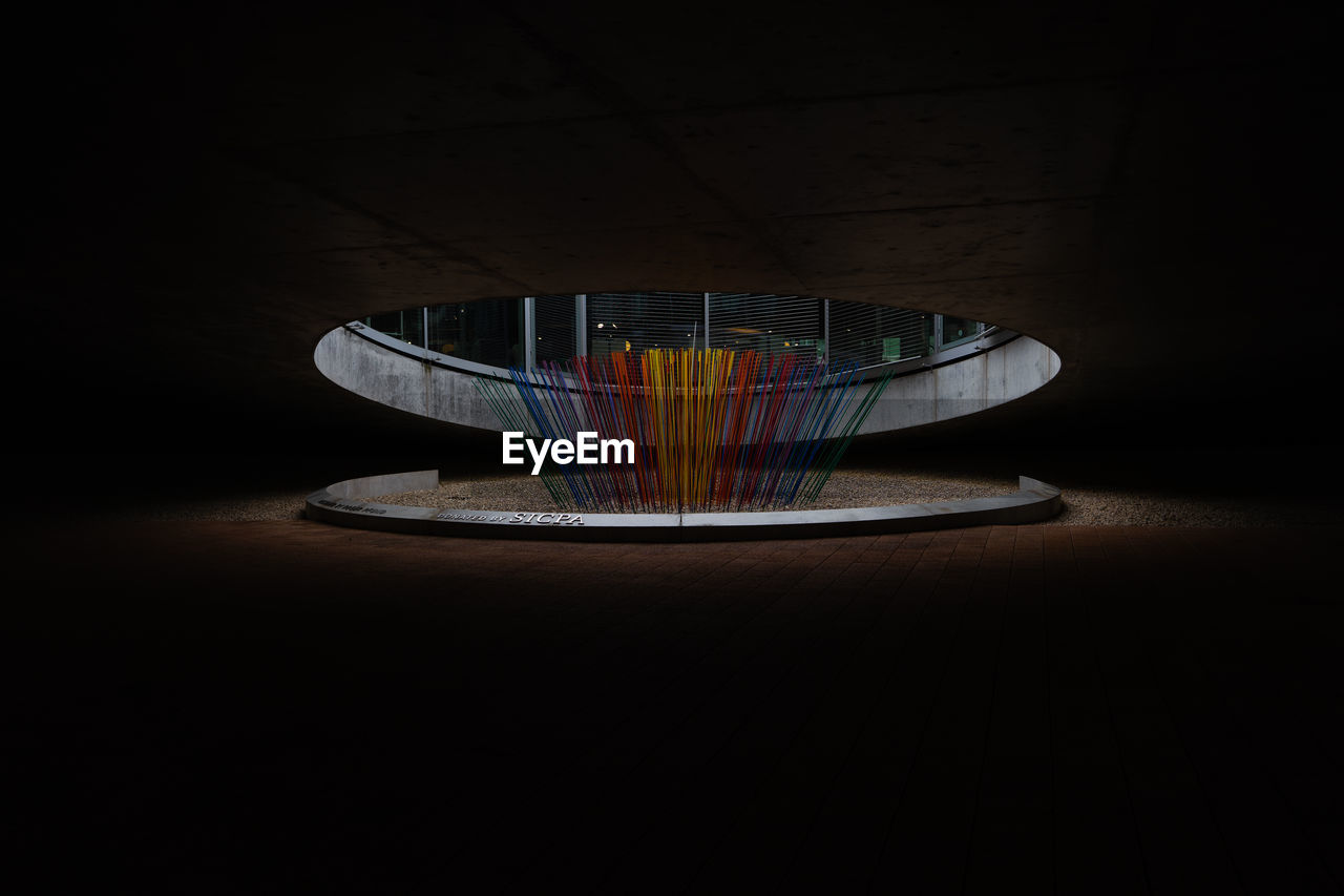 HIGH ANGLE VIEW OF MULTI COLORED GLASS ON TABLE AGAINST WALL