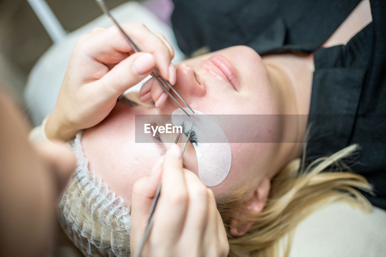 High angle view of customer applying eye patch at salon