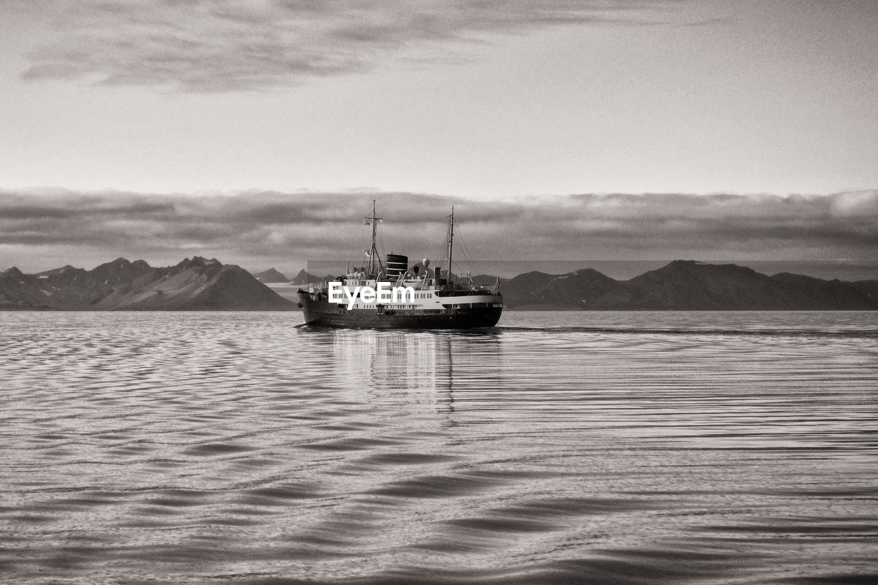 Sailboat in sea against sky, ship at svalbard coast