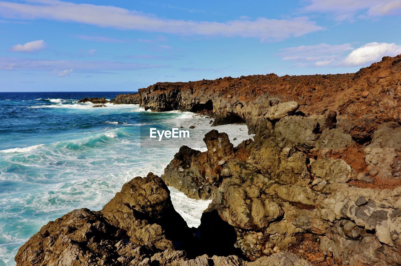 Rock formations by sea against sky