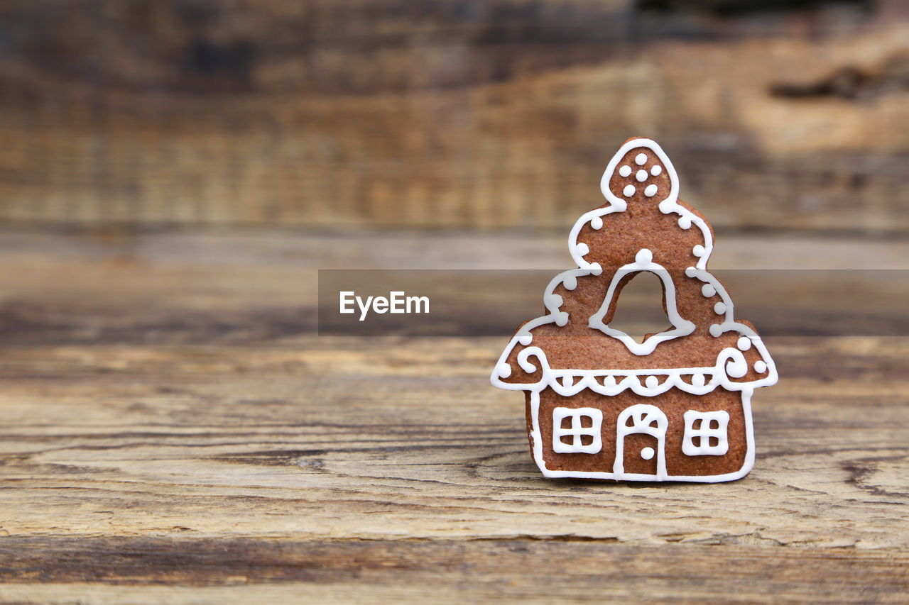 Close-up of house shaped gingerbread cookie on wooden table