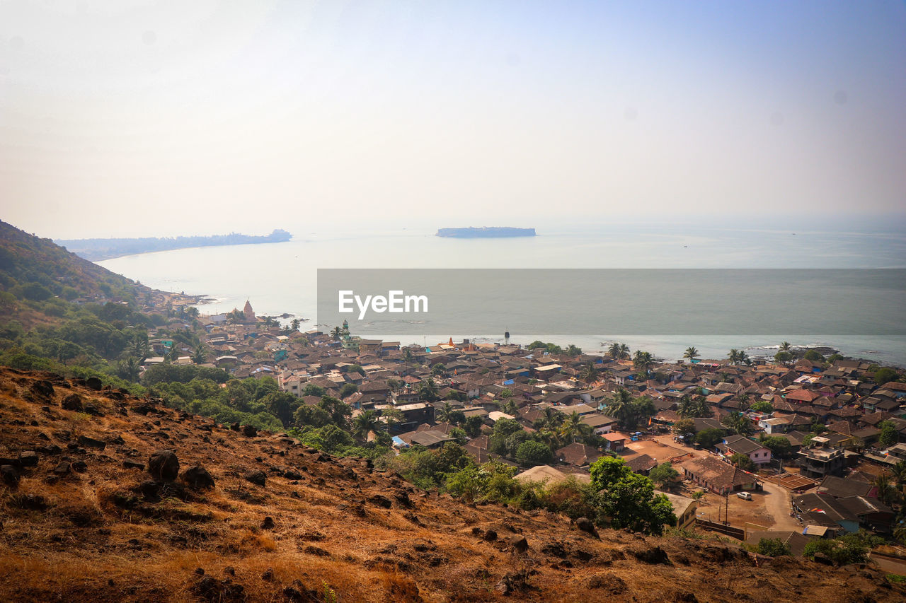 Scenic view of sea and village against clear sky