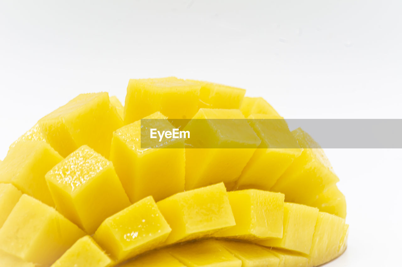 CLOSE-UP OF CHOPPED YELLOW AGAINST WHITE BACKGROUND