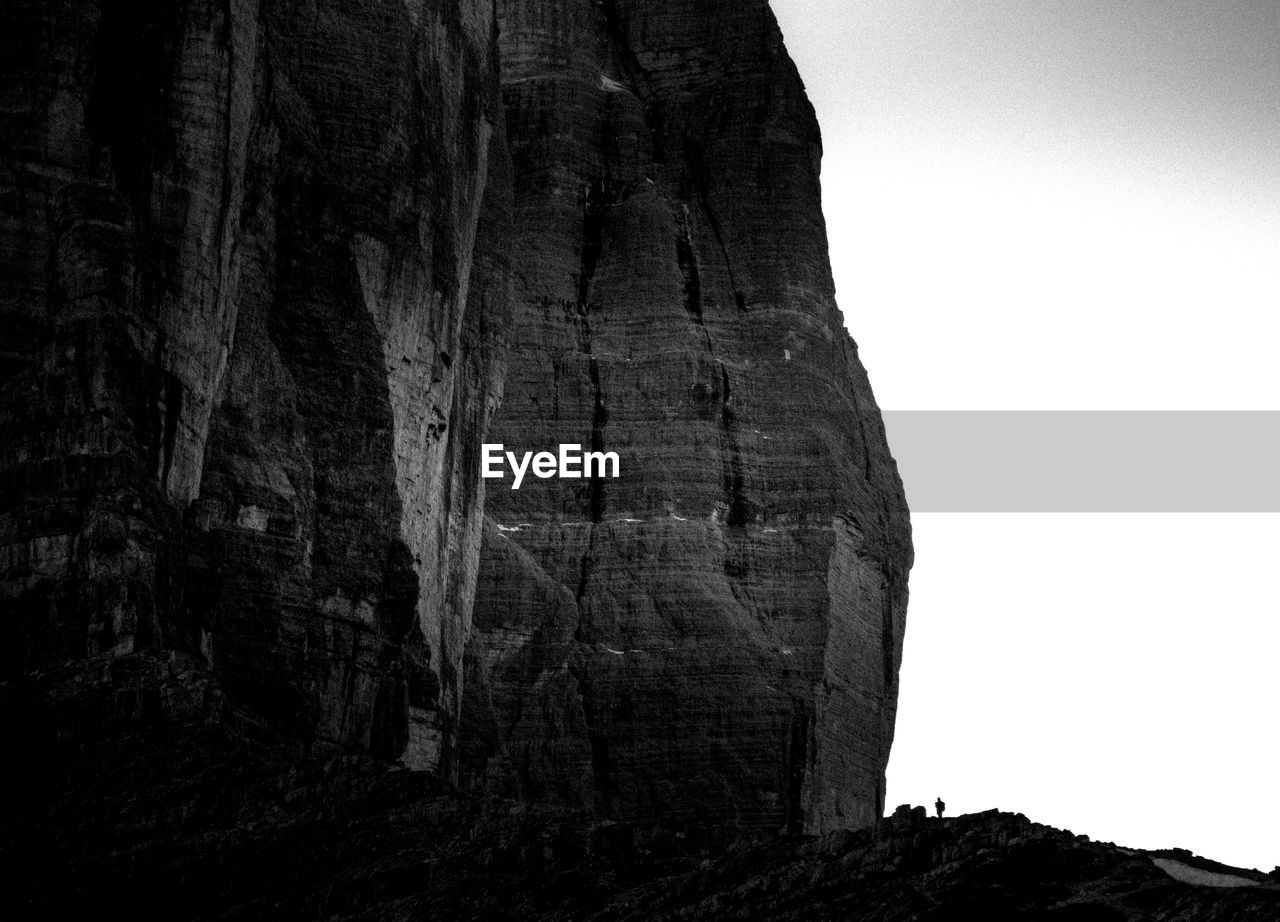 LOW ANGLE VIEW OF ROCK FORMATION AMIDST TREES AGAINST SKY