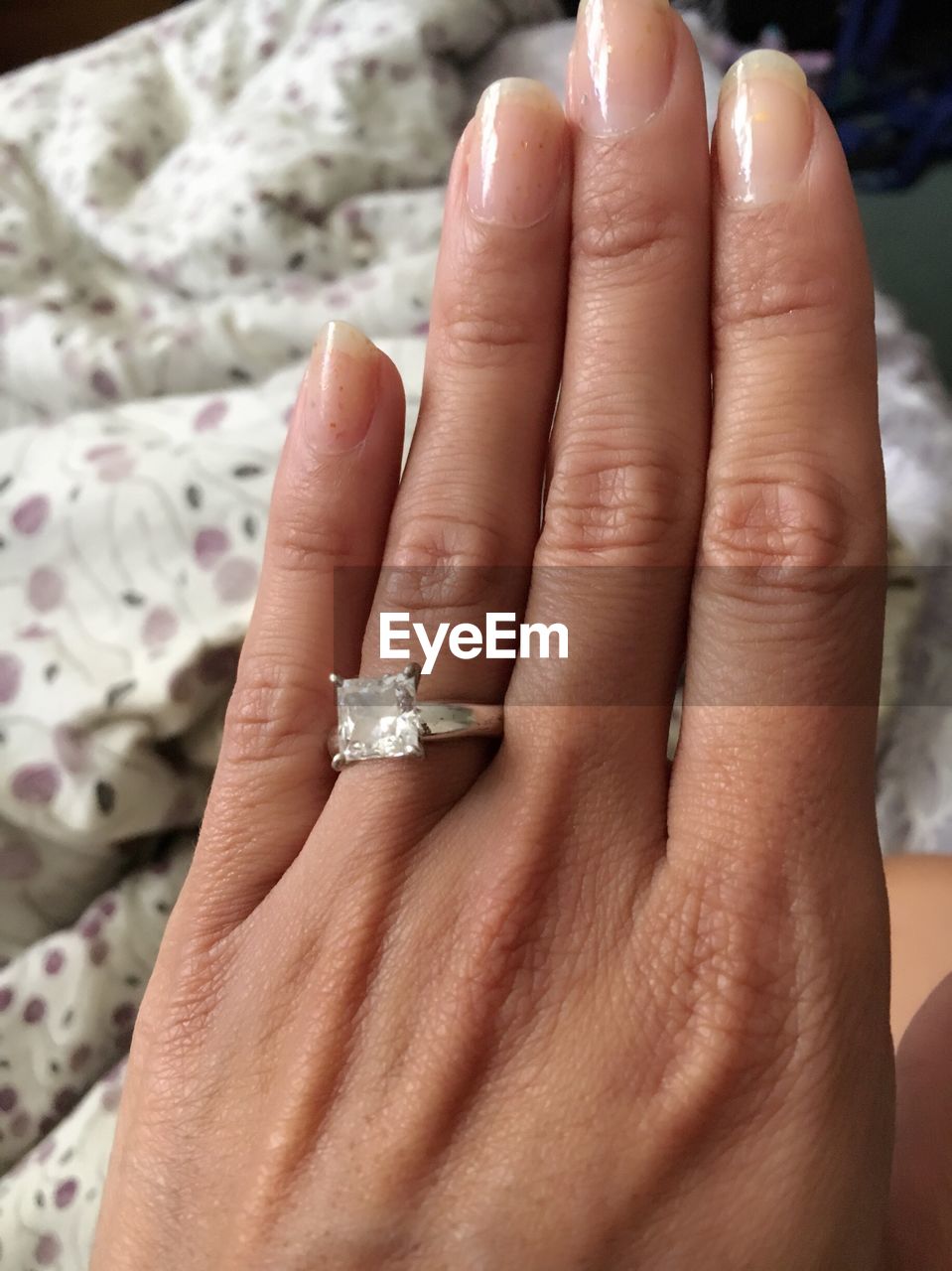 Close-up of woman wearing diamond ring at home