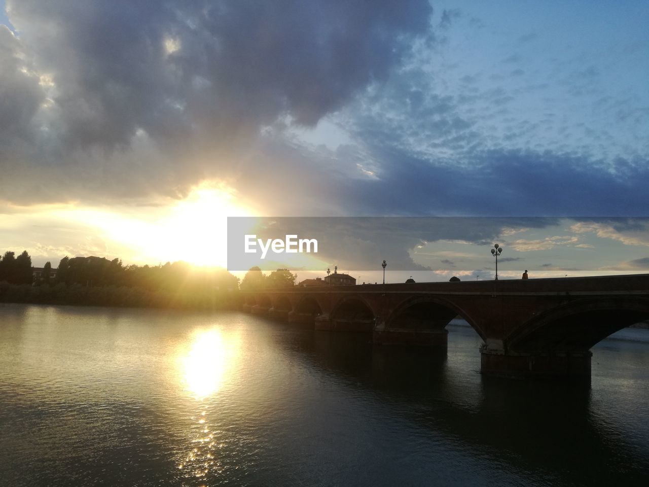 BRIDGE OVER RIVER IN CITY AGAINST SKY