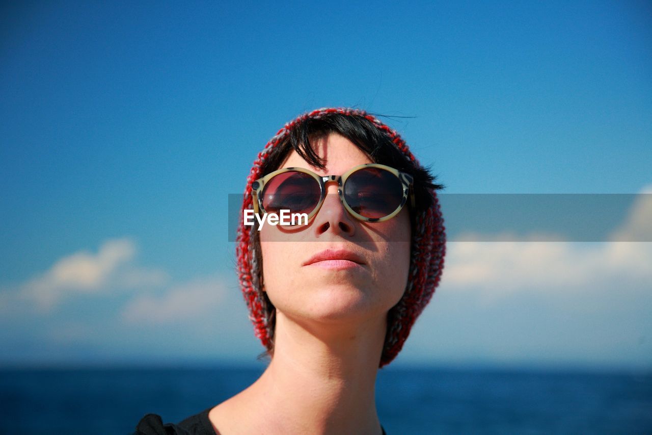 Portrait of woman wearing sunglasses against sky