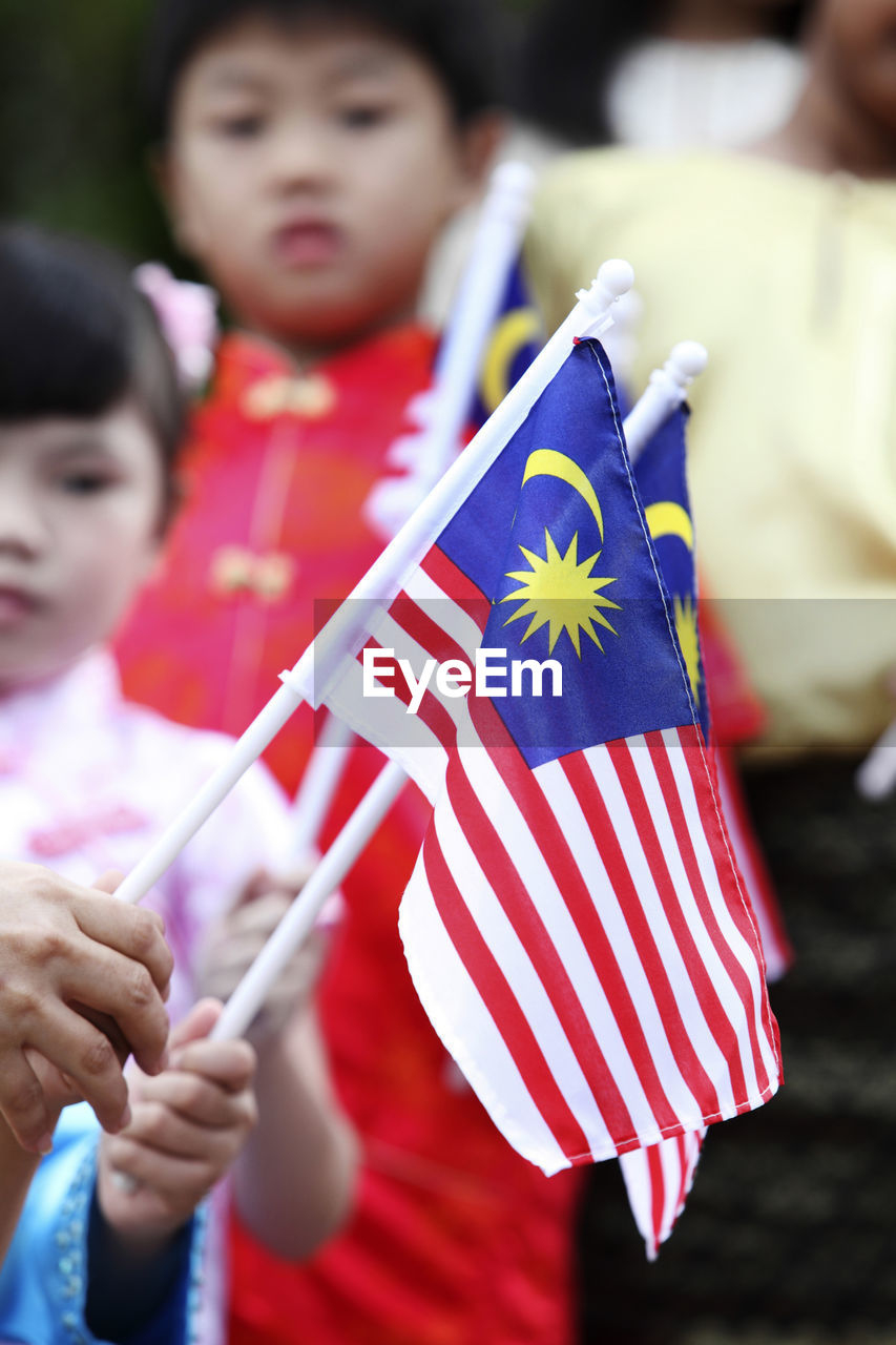Cute friends holding malaysia flags