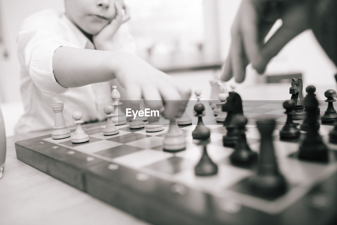 Midsection of boy playing chess