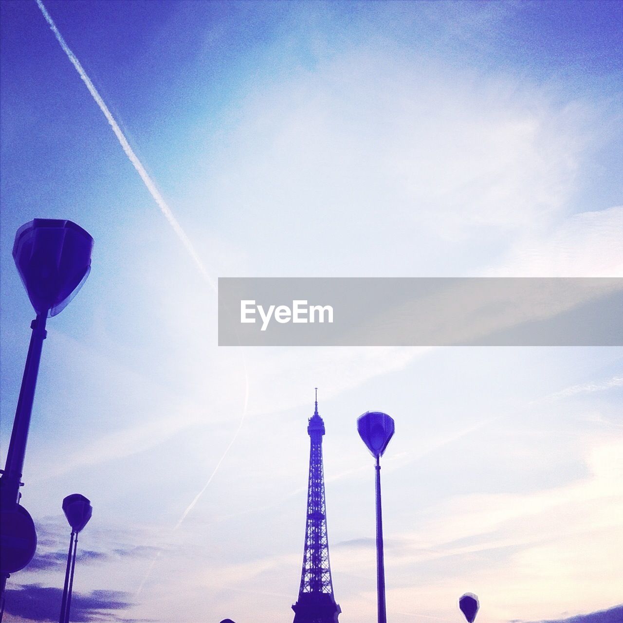 Eiffel tower and lamp posts against sky