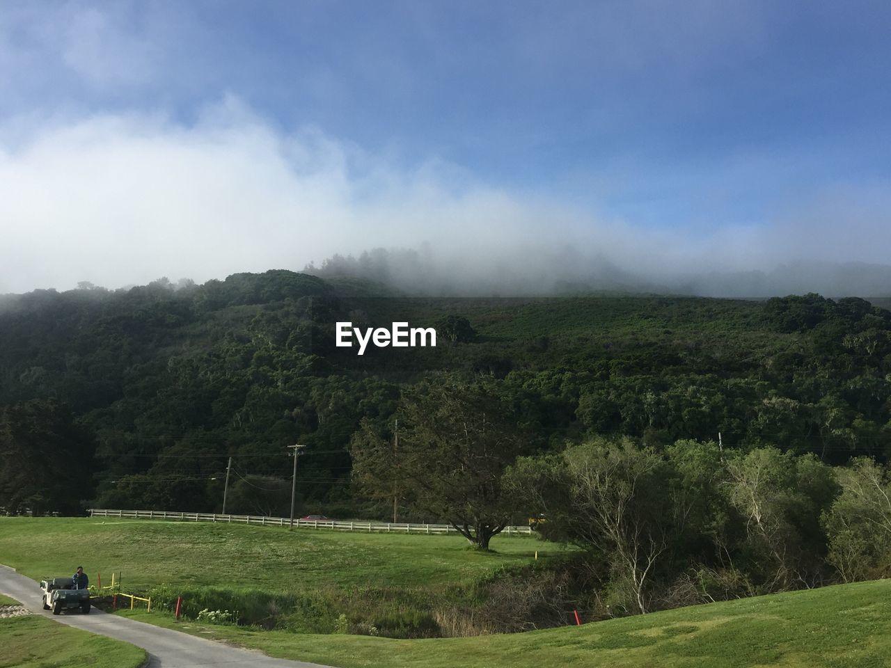 Scenic view of grassy field against cloudy sky