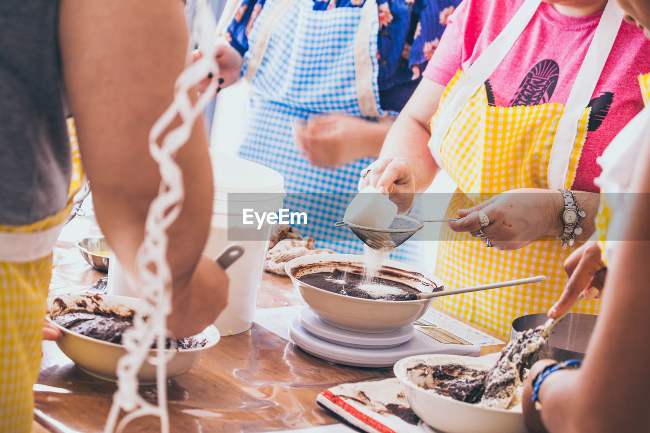 Midsection of people preparing food on table