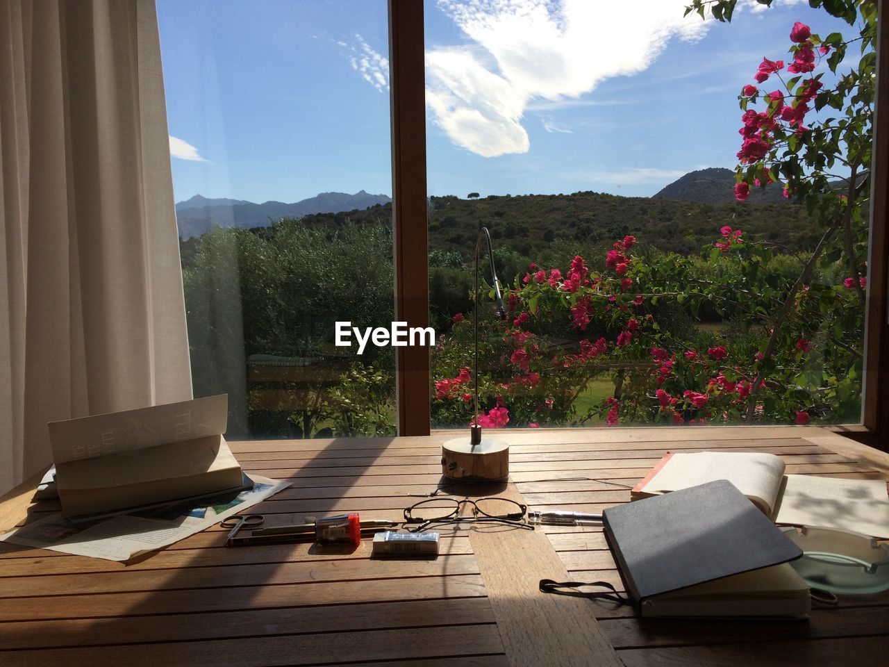 High angle view of books on table against glass window