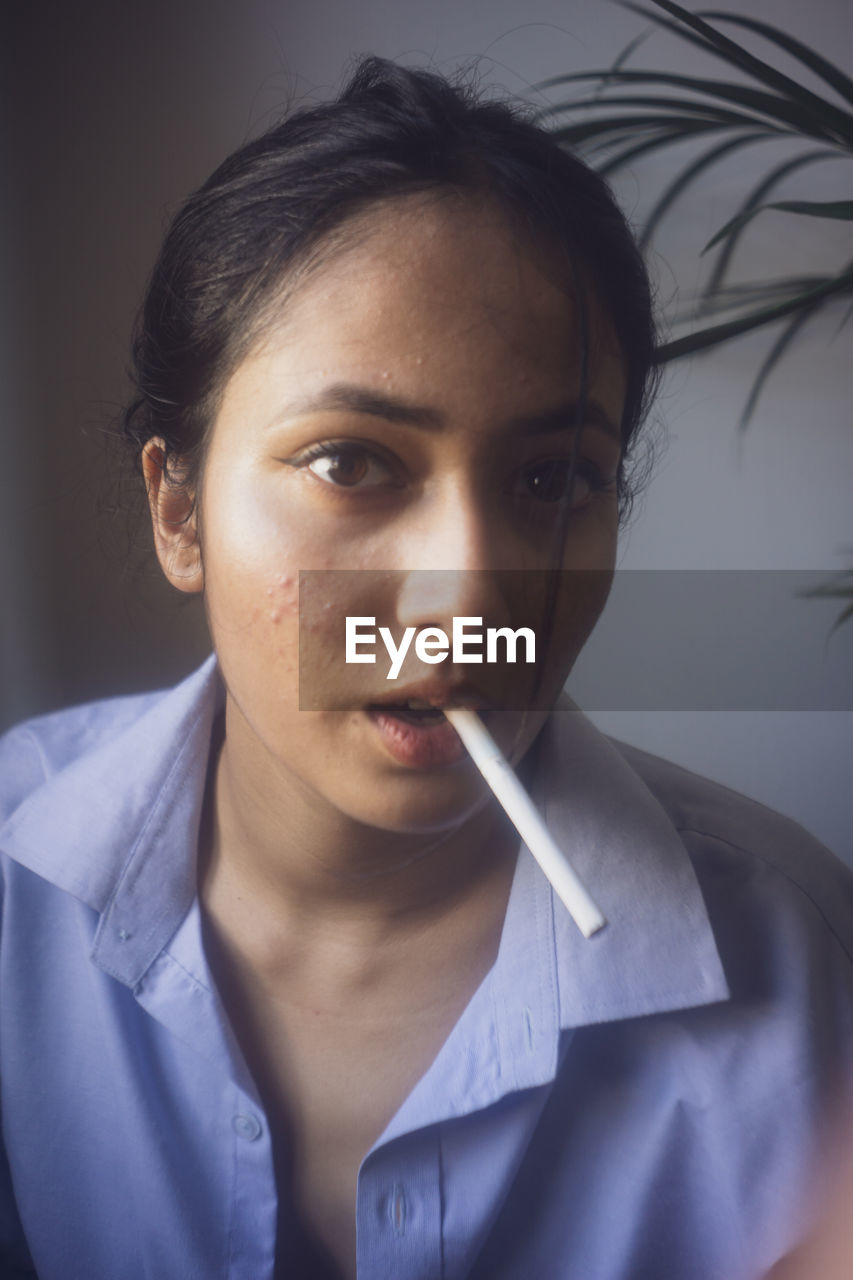 Close-up portrait of man smoking cigarette