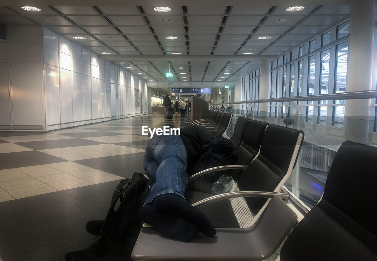 Man sleeping on bench at airport