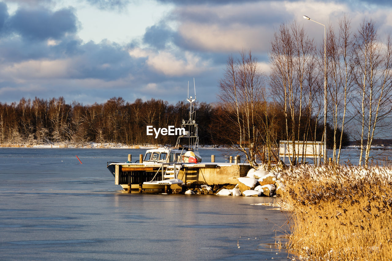 Boat on snow covered trees against sky