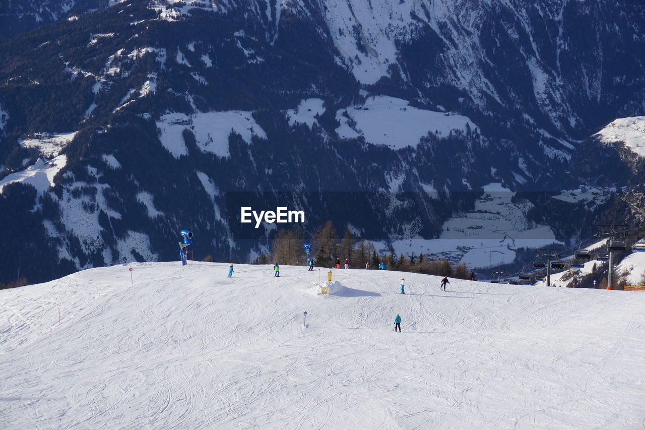 High angle view of people skiing on snow against mountains