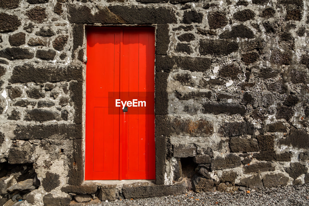 Closed red door of stone building