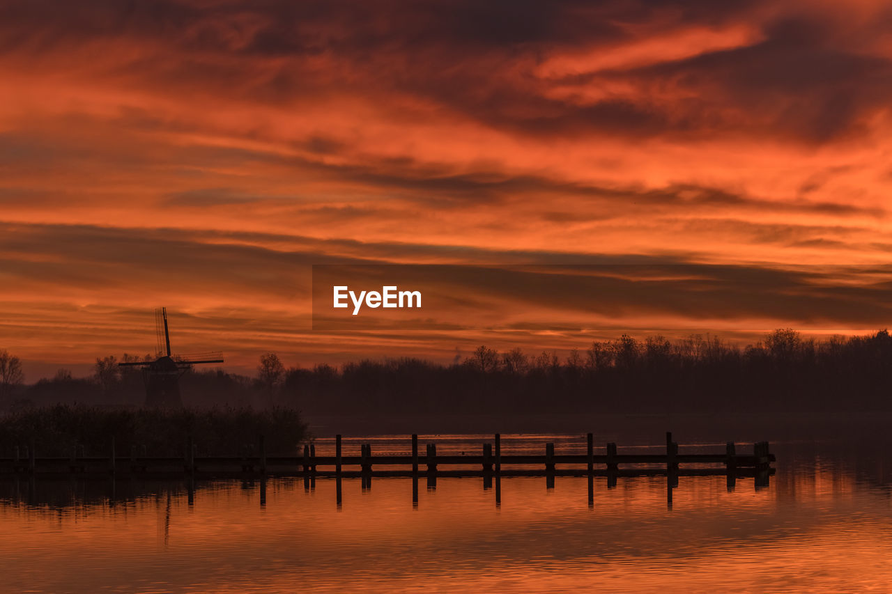 Scenic view of lake against orange sky