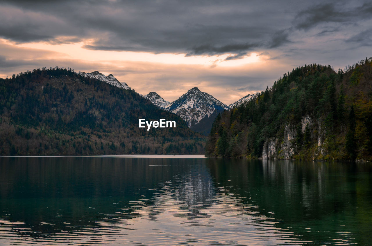 Scenic view of lake by mountains against sky