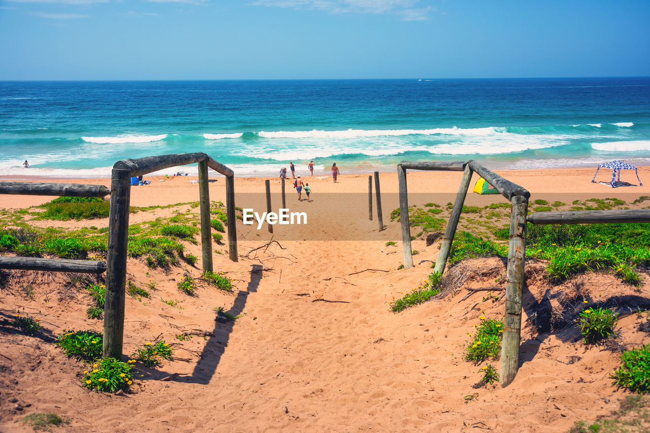 SCENIC VIEW OF BEACH AGAINST BLUE SKY