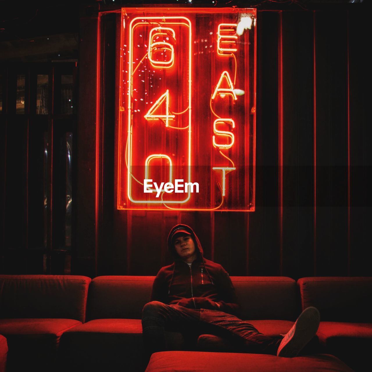 Full length of woman sitting in illuminated bar