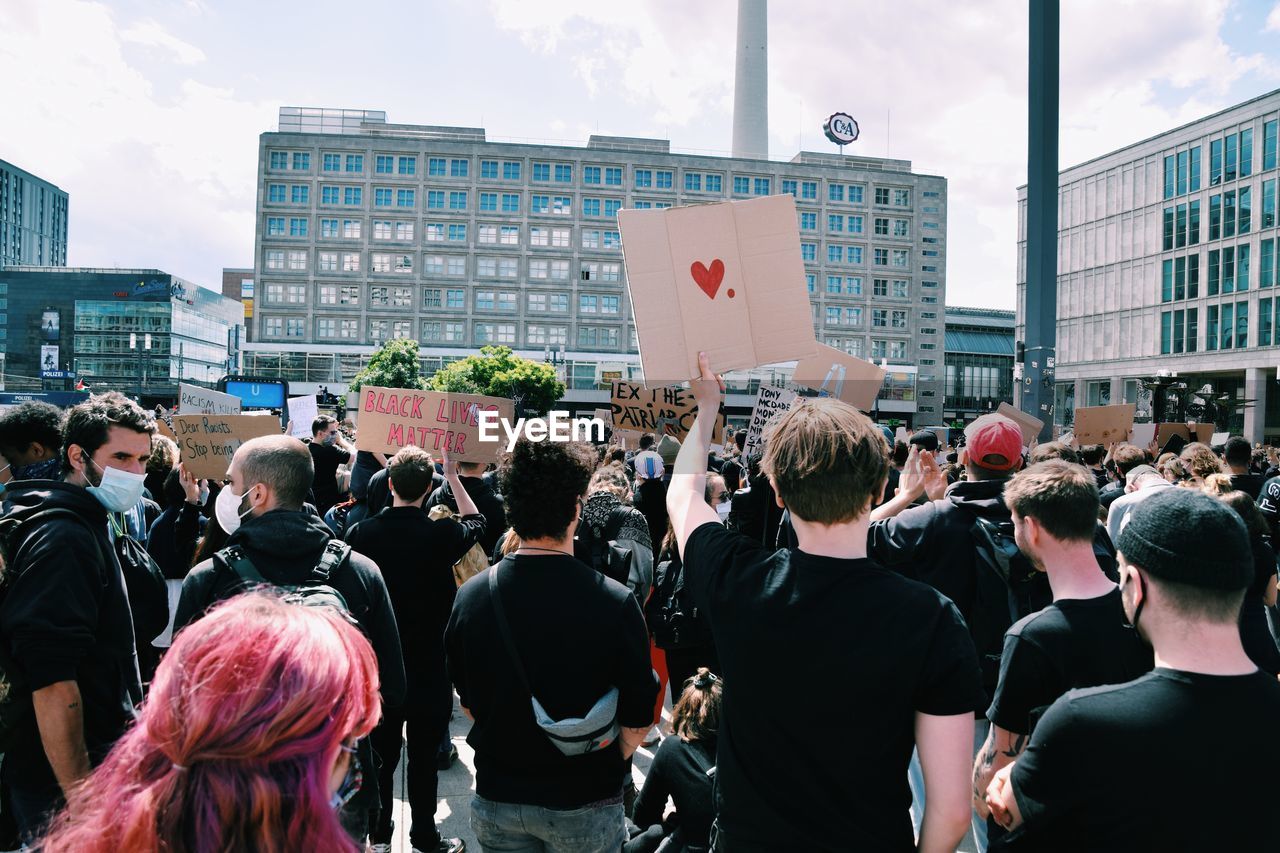 REAR VIEW OF PEOPLE ON STREET IN CITY