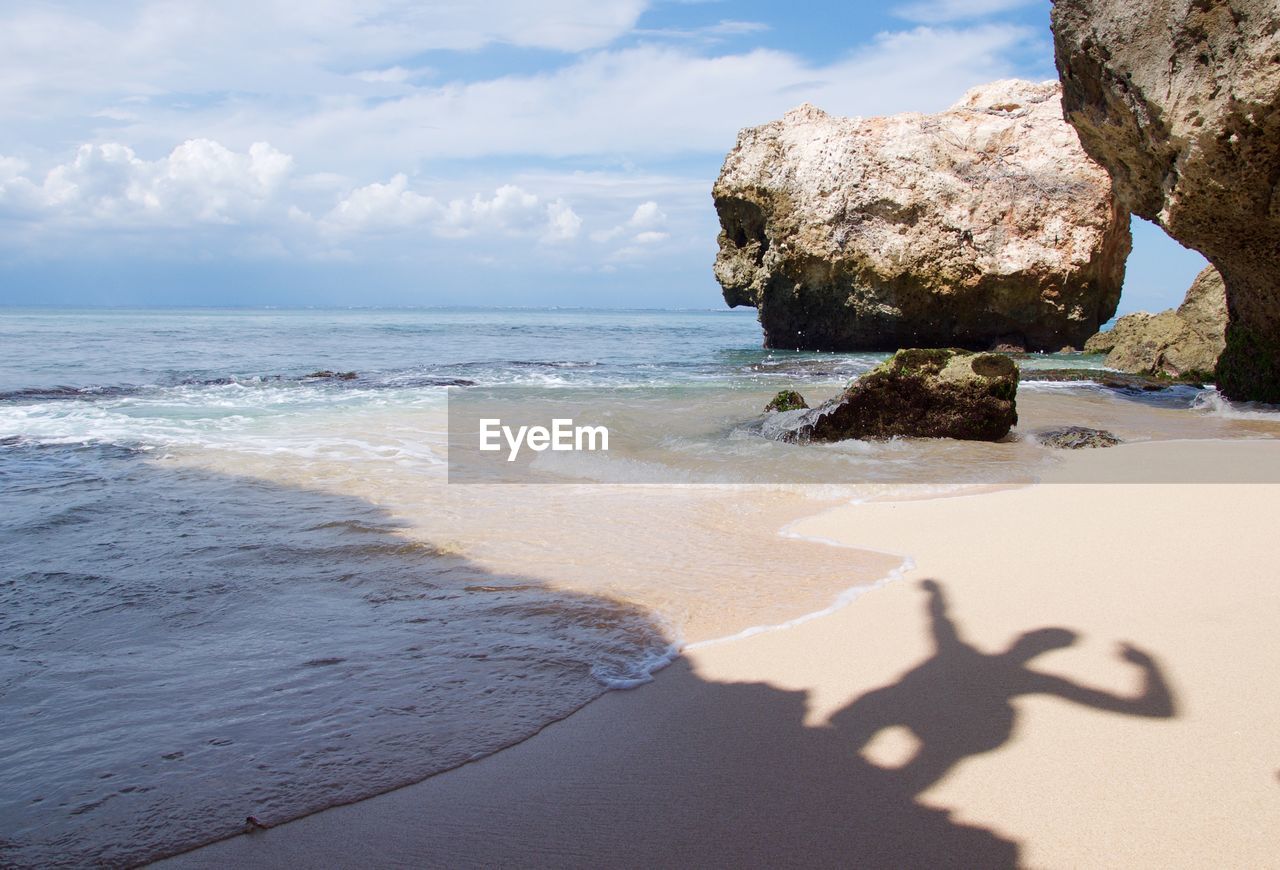 Shadow of man on beach during sunny day