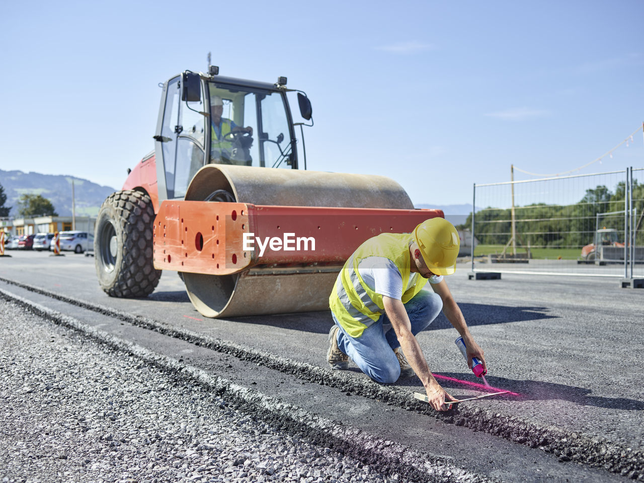 Worker marking roadside on construction site