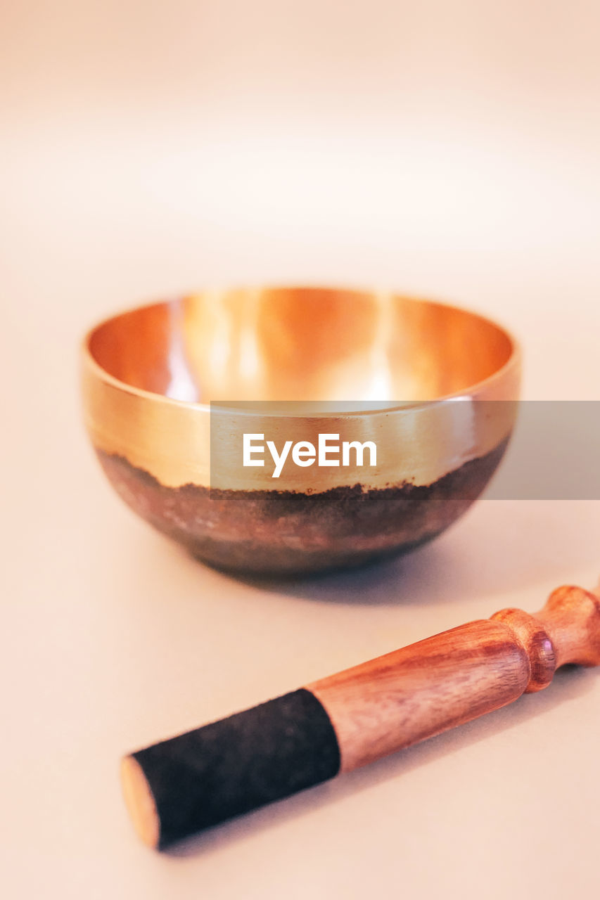 Bronze tibetan singing bowl with wooden stick on the white background. 