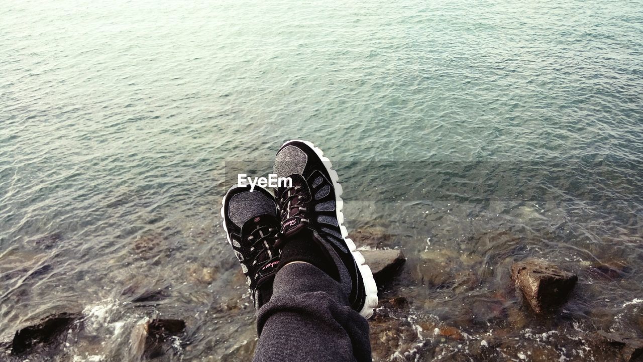 LOW SECTION OF PERSON RELAXING ON DECK