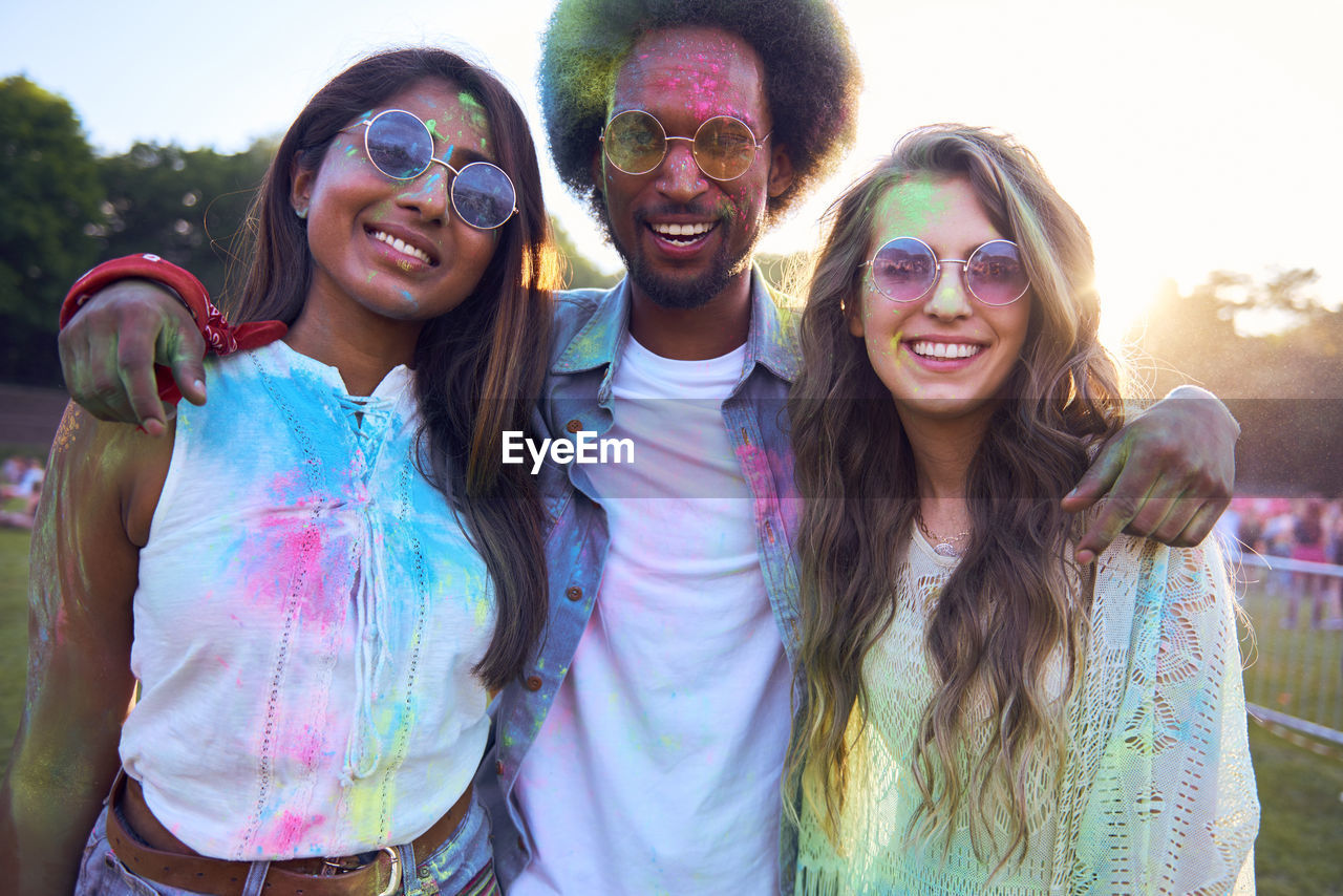 Portrait of happy friends covered with powder paint at carnival