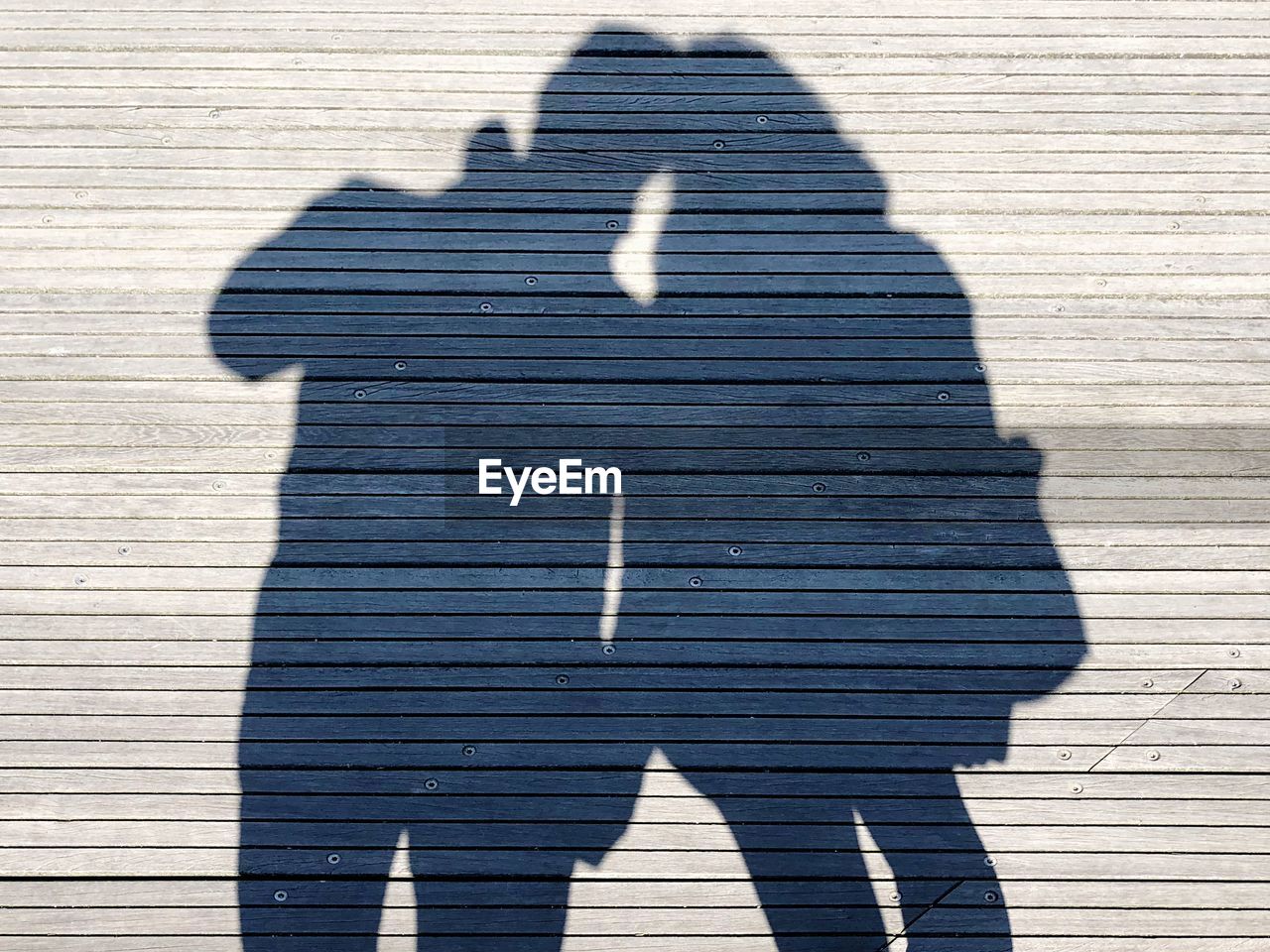 Shadow of couple on boardwalk