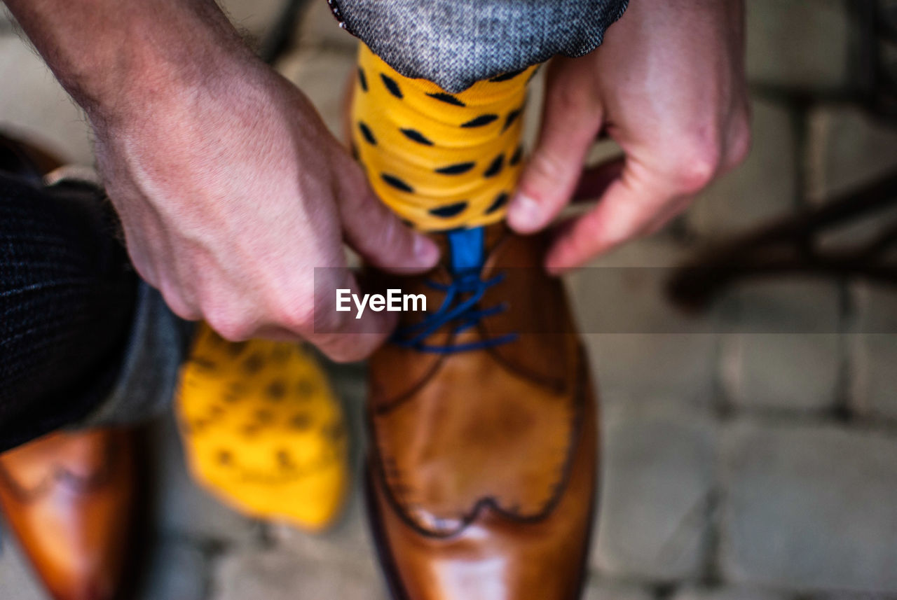 Close-up of man tying shoelaces