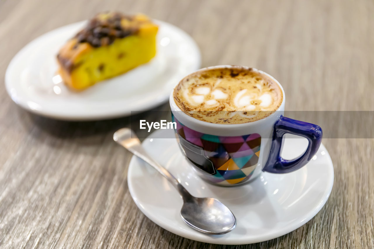 Cup of italian espresso coffee with a flower-shaped decoration in the milk foam.